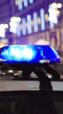 Gece bir polis arabasının çatısında teşhirci. Dikey video.