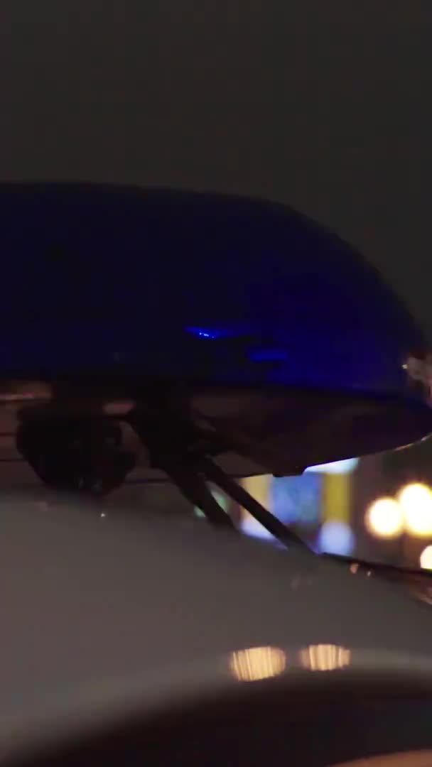 Gece bir polis arabasının çatısında teşhirci. Dikey video. — Stok video