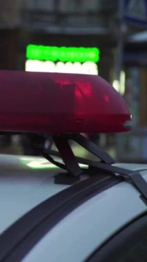 Gece bir polis arabasının çatısında teşhirci. Dikey video.