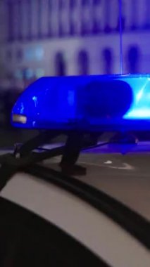 Gece bir polis arabasının çatısında teşhirci. Dikey video.