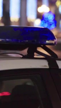 Gece bir polis arabasının çatısında teşhirci. Dikey video.