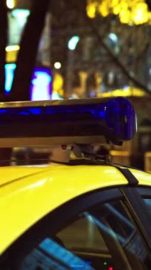 Gece bir polis arabasının çatısında teşhirci. Dikey video.