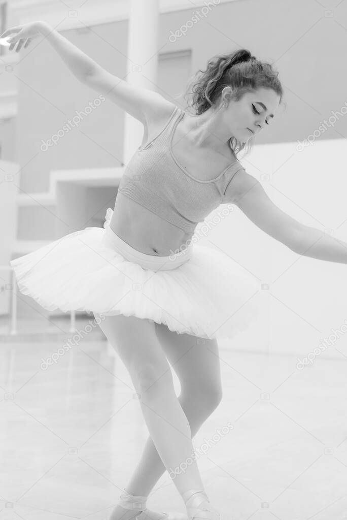 Black and white photo of flexible slender young girl ballerina. BW