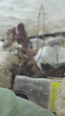 Deniz kıyısındaki dikey videoda plastik çöpler