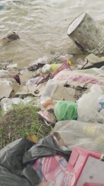 Deniz kıyısındaki dikey videoda plastik çöpler