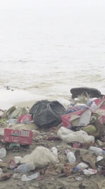 Deniz kıyısındaki dikey videoda plastik çöpler