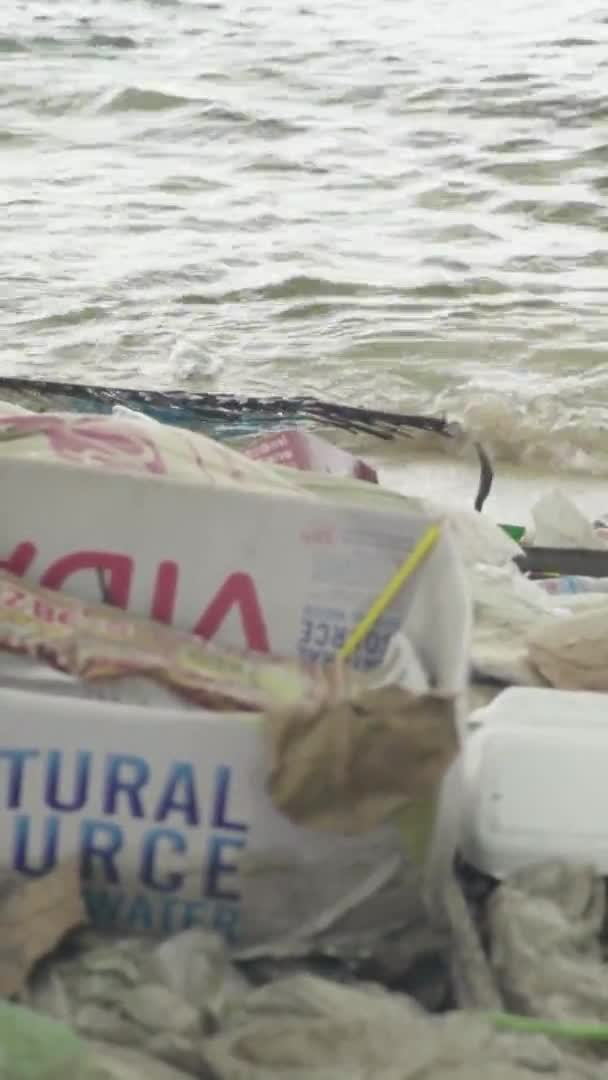 Basura de plástico en la orilla del mar Video vertical — Vídeos de Stock