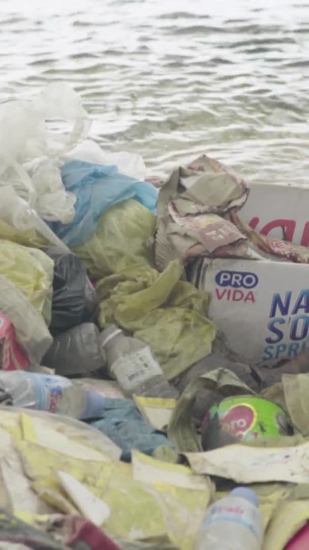 Basura de plástico en la orilla del mar Video vertical — Vídeo de stock