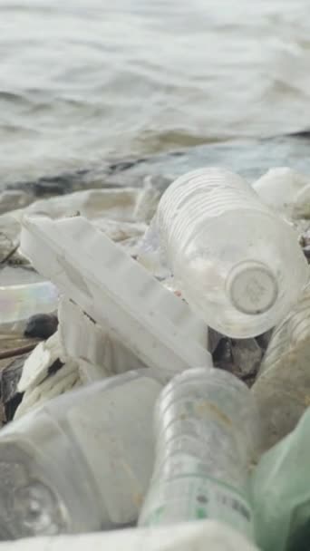 Пластиковый мусор на берегу Вертикальное видео — стоковое видео