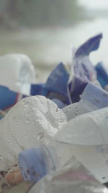 Deniz kıyısındaki dikey videoda plastik çöpler