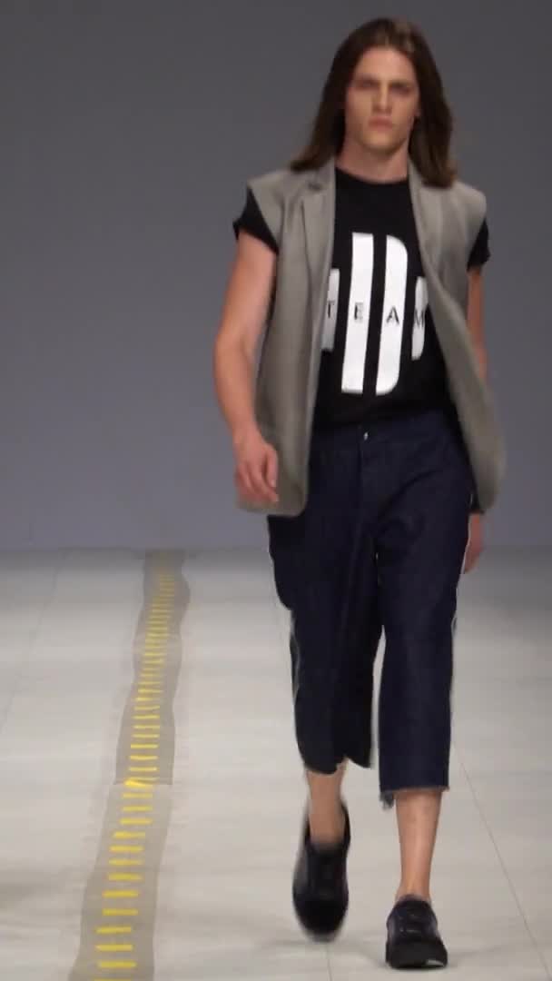 Mužský model kráčí po lávce Vertikální video — Stock video