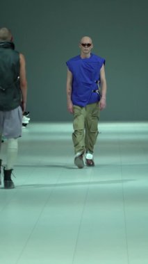 Podyumda yürüyen erkek model dikey video