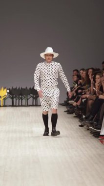 Podyumda yürüyen erkek model dikey video