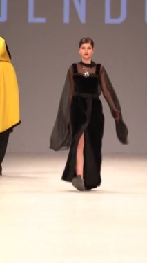 Woman model on the catwalk during a fashion show Vertical video