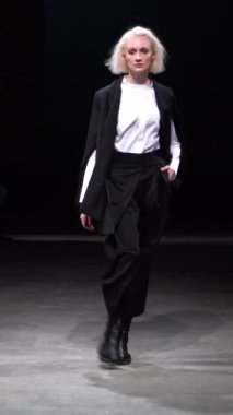 Woman model on the catwalk during a fashion show Vertical video