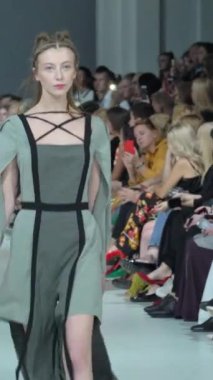 Woman model on the catwalk during a fashion show Vertical video