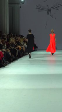Woman model on the catwalk during a fashion show Vertical video