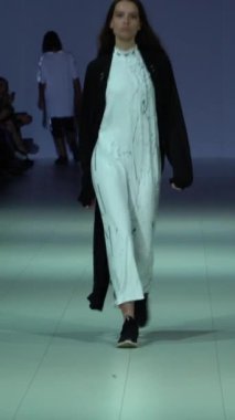 Woman model on the catwalk during a fashion show Vertical video