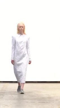 Woman model on the catwalk during a fashion show Vertical video