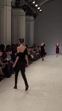 Woman model on the catwalk during a fashion show Vertical video