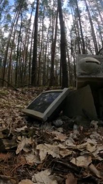 Ormandaki bir hurdalıkta bilgisayarın dikey videosu, yavaş çekim.