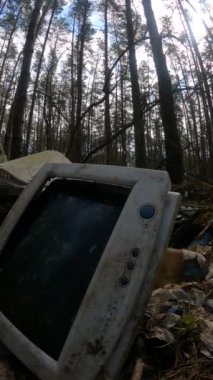 Ormandaki bir hurdalıkta bilgisayarın dikey videosu, yavaş çekim.