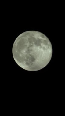 Gece gökyüzünde dolunayın dikey videosu
