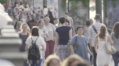 Şehirdeki hayat: insanların siluetleri kalabalıkta yürüyor, ağır çekimde.