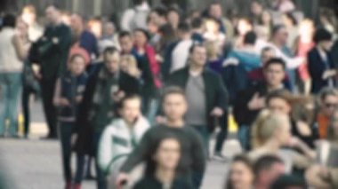 Şehirdeki hayat: insanların siluetleri kalabalıkta yürüyor, ağır çekimde.