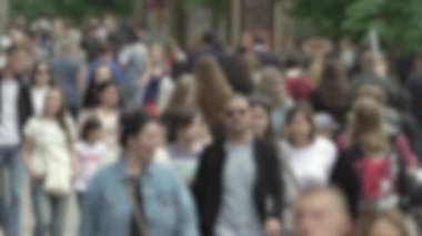 Büyük şehir hayatı: insanların siluetleri kalabalık içinde yürüyor, ağır çekimde.