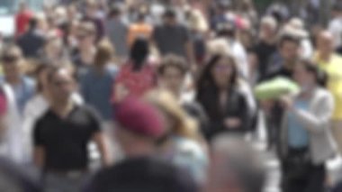 Büyük şehir hayatı: insanların siluetleri kalabalık içinde yürüyor, ağır çekimde.