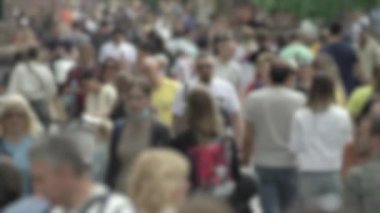 Büyük şehir hayatı: insanların siluetleri kalabalık içinde yürüyor, ağır çekimde.