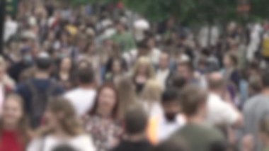 Büyük şehir hayatı: insanların siluetleri kalabalık içinde yürüyor, ağır çekimde.