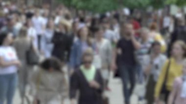 Büyük şehir hayatı: insanların siluetleri kalabalık içinde yürüyor, ağır çekimde.