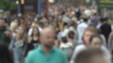 Büyük şehir hayatı: insanların siluetleri kalabalık içinde yürüyor, ağır çekimde.