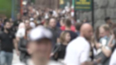 Büyük şehir hayatı: insanların siluetleri kalabalık içinde yürüyor, ağır çekimde.