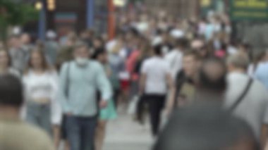 Büyük şehir hayatı: insanların siluetleri kalabalık içinde yürüyor, ağır çekimde.