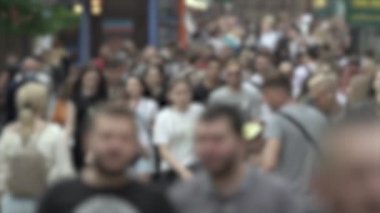 Büyük şehir hayatı: insanların siluetleri kalabalık içinde yürüyor, ağır çekimde.