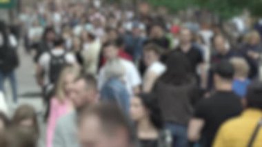 Büyük şehir hayatı: insanların siluetleri kalabalık içinde yürüyor, ağır çekimde.