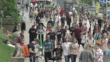 Büyük şehir hayatı: insanların siluetleri kalabalık içinde yürüyor, ağır çekimde.