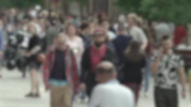 Büyük şehir hayatı: insanların siluetleri kalabalık içinde yürüyor, ağır çekimde.