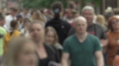 Büyük şehir hayatı: insanların siluetleri kalabalık içinde yürüyor, ağır çekimde.