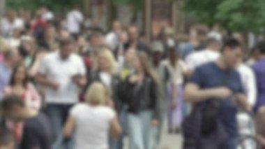 Büyük şehir hayatı: insanların siluetleri kalabalık içinde yürüyor, ağır çekimde.