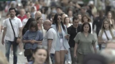 Birçok insan metropol caddesi boyunca yürür.