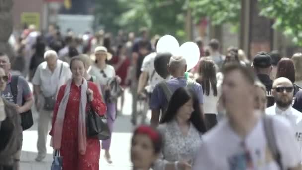 Många människor går längs gatan i metropolen — Stockvideo