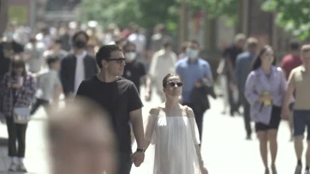 Många människor går längs gatan i metropolen — Stockvideo