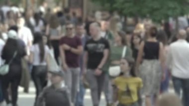 Silhouettes of people walking in the crowd