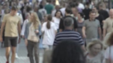 Silhouettes of people walking in the crowd