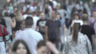 Silhouettes of people walking in the crowd