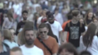 Silhouettes of people walking in the crowd